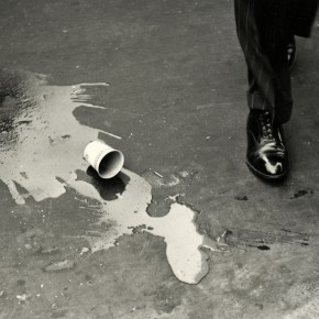 spilled coffee cup on street next to man's foot