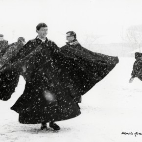 priests wearing long black coats spinning in the snow