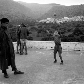 group of boys playing in the square in front of mountains in Crete
