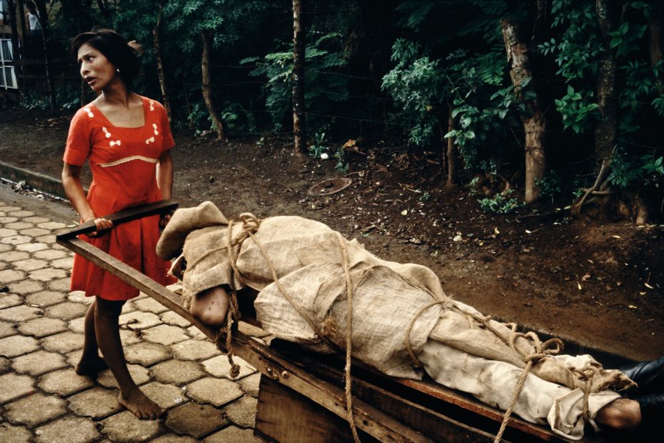 Monimbo woman carrying her dead husband home to be buried in their backyard, Masaya, 1979