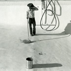 man in cowboy hat mopping empty swimming pool