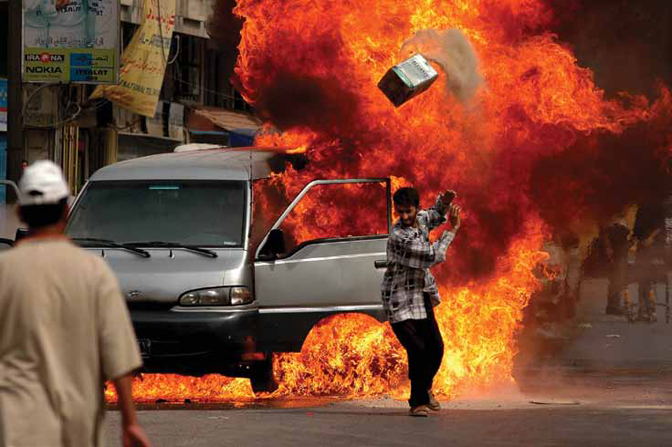 Ashley Gilbertson<br>Iraqi’s attempt to extinguish a van that caught fire on Saadoun Street in Baghdad, Iraq on May 30, 2004