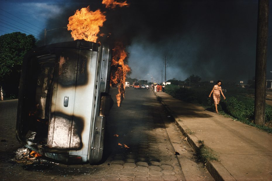 Car of a Somoza informer burning in Managua, 1978
