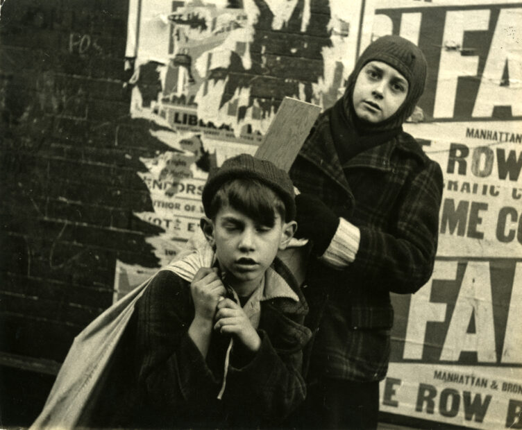 Boys in front of a poster-clad brick wall, New York City