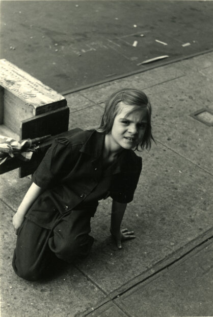 Girl kneels on the sidewalk, New York City,